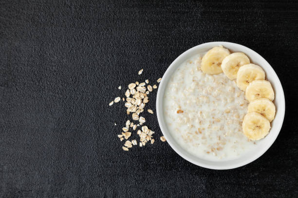 istock Oatmeal with banana slices - top view - dark background 1425482067