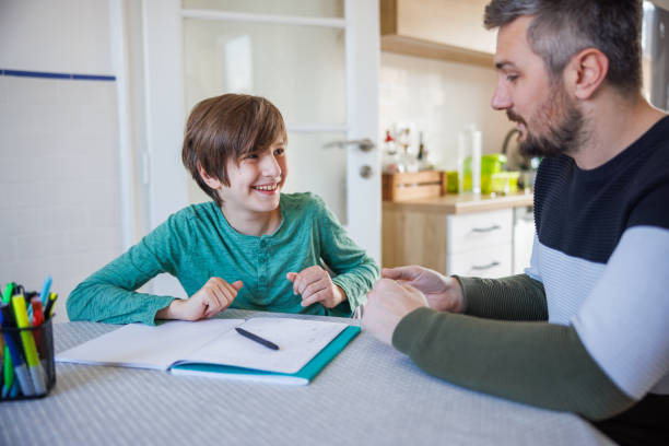 istock Happy boy doing homework with his father in the dining room 1425487785