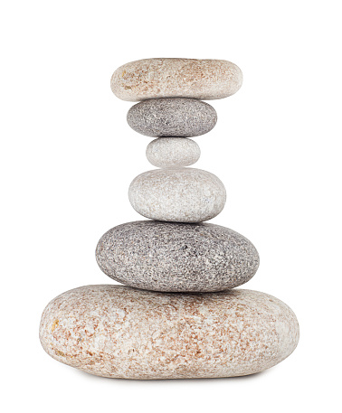 Vertical shoot of balanced pebbles on beach sand