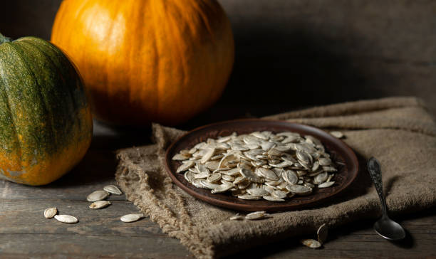 istock Pumpkin seeds on a brown plate on a wooden background. 1425490932