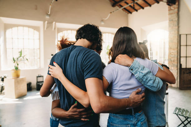 istock People embracing together in their office 1425491773