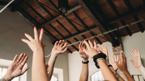 Group of people with raised hands are celebrating together. Team building and teamwork concept. Multiethnic group of people.