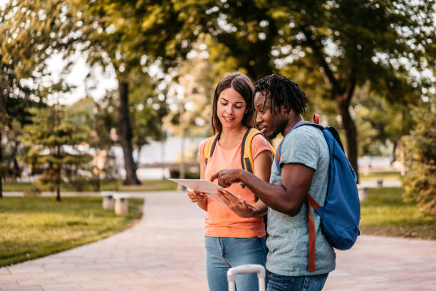 istock Happy tourist couple using map in foreign city 1425491896