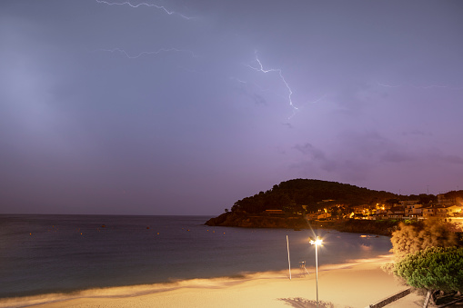 Cala Fosca in Costa Brava, night storm with lightning in the sky