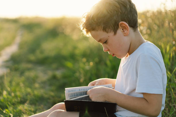 istock Christian boy holds bible in her hands 1425501416