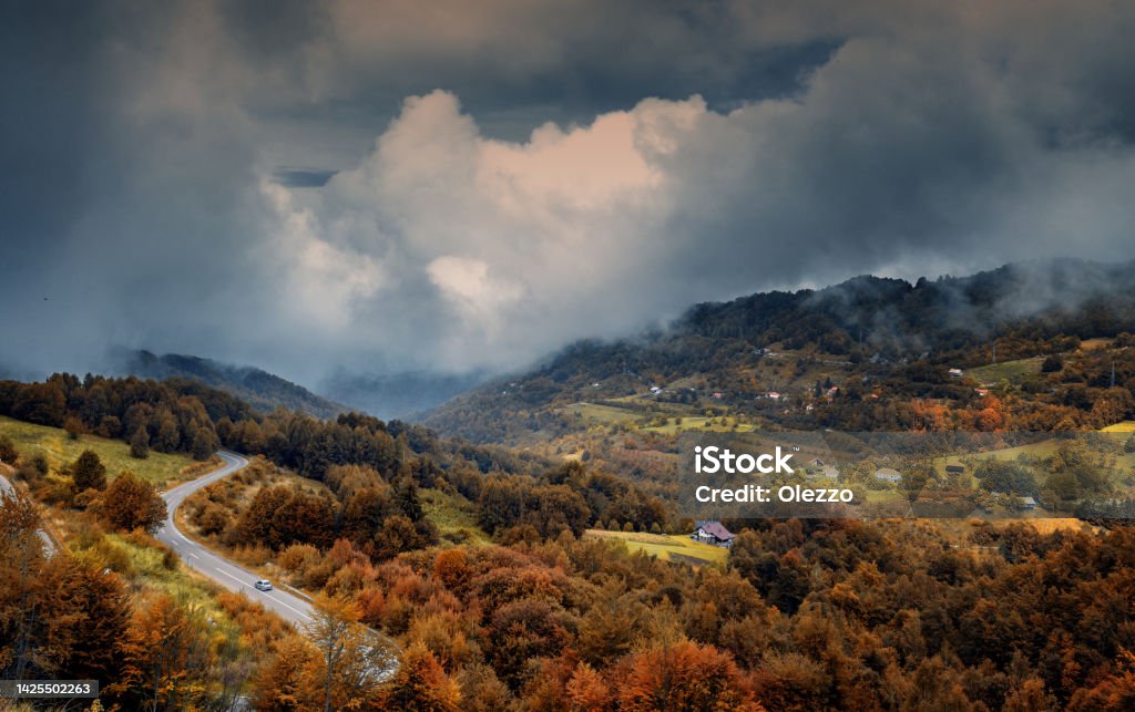 Road and village in autumn mountain forest, beautiful bright landscape with cloudy dramatic sky Road and village in autumn mountain forest, beautiful bright landscape with dramatic sky Kopaonik Stock Photo