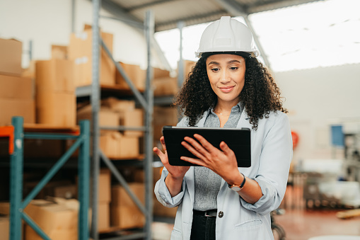 Stock, industry and business woman on tablet working in a warehouse, plant or factory. Happy manager, worker or industrial storage and logistics employee checking inventory or delivery on tech.