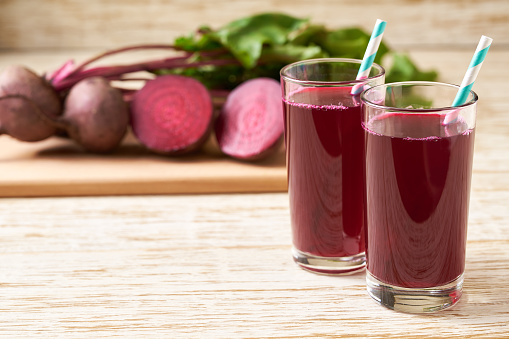 Glasses of beetroot juice with vegetables on a wooden table. Fresh beetroot and juice (smoothies).