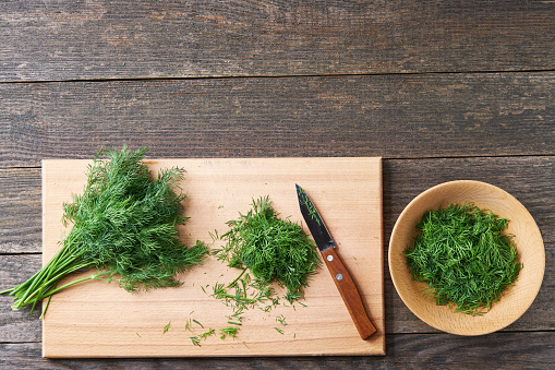 Parsley on cutting board on darc rustic background.Top view