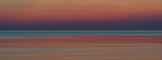 Incredible beautiful pink sunset over the Baltic sea. Almost dusk. The sea is calm and peaceful during this magic bright summer sunset time. Colorful background
