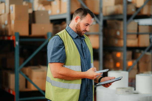 istock Warehouse, stock and a man with a phone and tablet checking inventory online for delivery. Tech, cargo and retail, a logistics worker with product list to package and box for global shipping service. 1425508577
