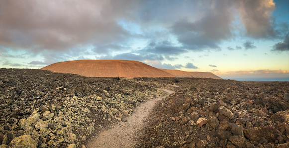 Volcanic landscape near Mancha Blanca looking to the Caldera Blanca on the island of Lanzarote shortly after sunrise.