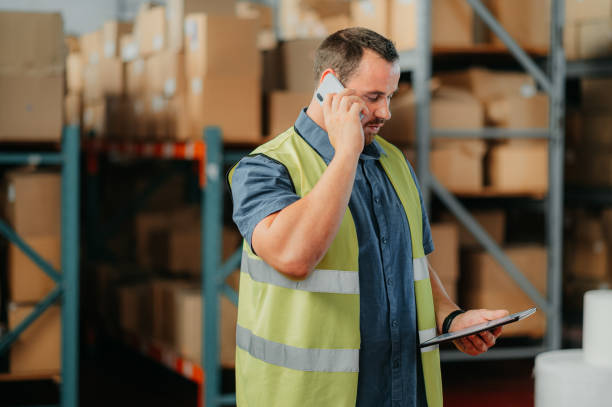 istock Serious employee on a phone call, doing inventory, tracking an order and package delivery details. Logistics, communication and warehouse manager checking online stock on a digital tablet at work. 1425510060