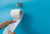 Woman hand pulling toilet paper