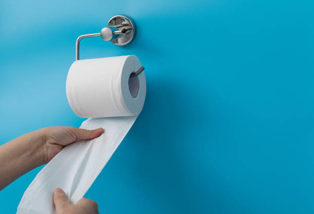 Woman hand pulling toilet paper stock photo