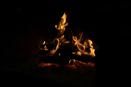 A beautiful photograph of the dancing flames of a camp fire at night.