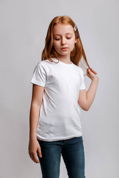 istock Redhead little kid model posing in white t-shirt on grey background 1425515526