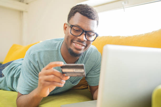 istock Cheerful man doing online shopping 1425517670