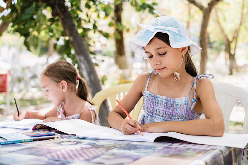 Little Child Girls Drawing Pictures Outdoors In The Park In Summer Season