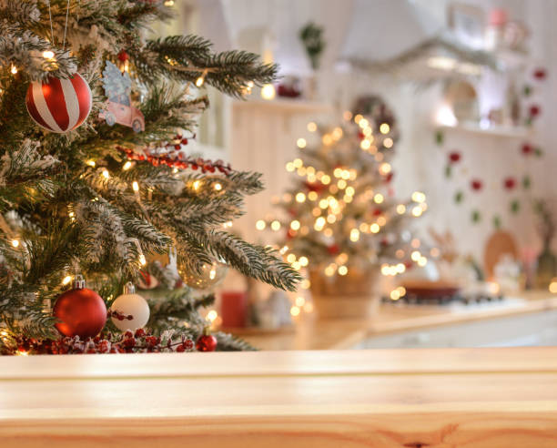 クリスマスツリーの背景にある空の木製のテーブルとぼやけたクリスマスキッチン、金色のボケ。クリスマスの背景。メリークリスマスと新年あけましておめでとうございます!製品モンター