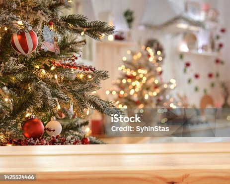 istock Empty wooden table on the background of christmas tree and blurred christmas kitchen, golden bokeh.Christmas background. Merry Christmas and Happy New Year! Ready for product montage.Mockup. 1425524466