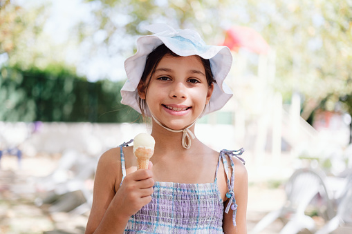 Portrait Of Little Child Girl Having Her Ice-cream Outdoors In Summer Season