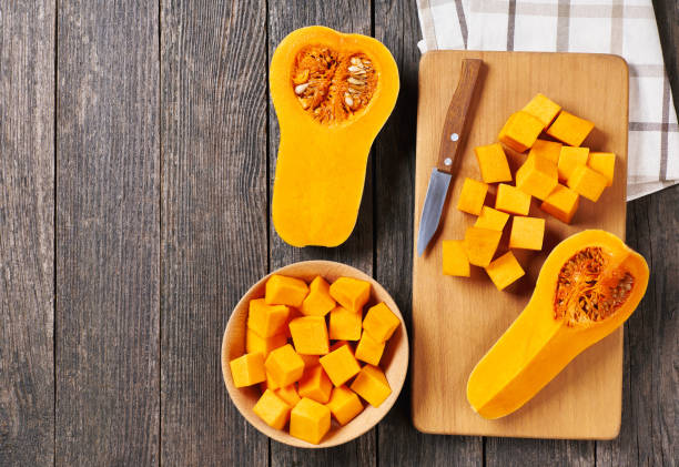 istock Diced butternut squash on wooden cutting board, top view. Cooking cake making process. 1425530593