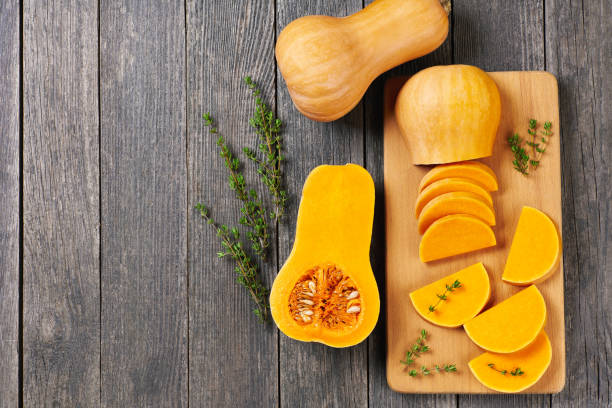 istock Butternut squash slices with thyme on a wooden table, copy space for your text. 1425530604