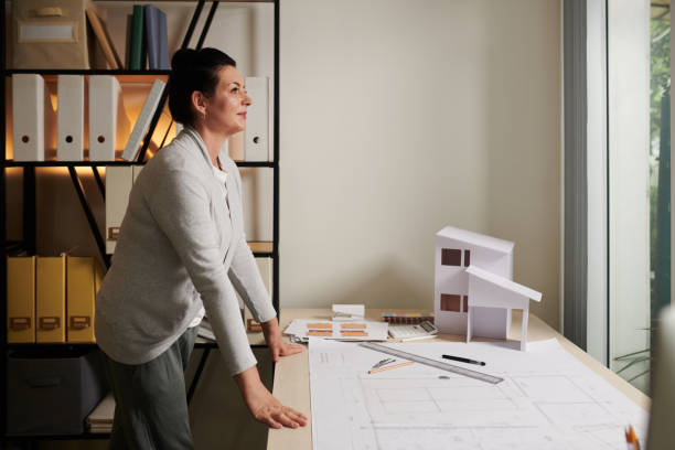 istock Pensive Architect Standing at Office Desk 1425531495
