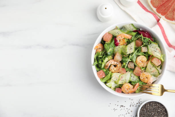 istock Delicious pomelo salad with shrimps served on white  table, flat lay. Space for text 1425540367