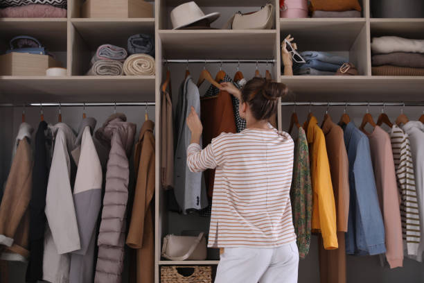 istock Young woman choosing clothes in wardrobe closet, back view 1425540699