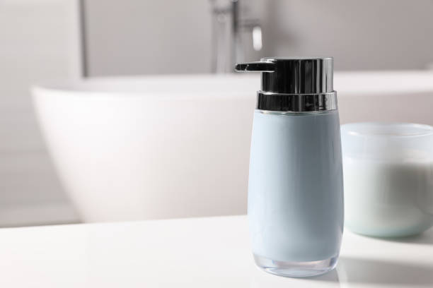 istock Dispenser of liquid soap on white table in bathroom, space for text 1425541098