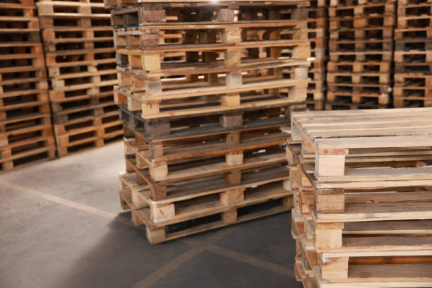 istock Many empty wooden pallets stacked in warehouse. Space for text 1425543572