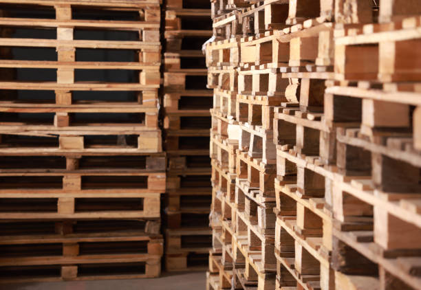 istock Many empty wooden pallets stacked in warehouse 1425543834