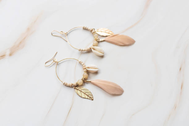 istock A pair of earrings on a marble background with copy space. 1425550001