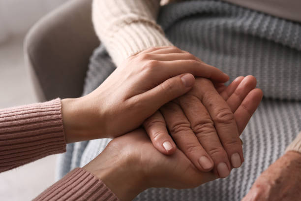 istock Young and elderly women holding hands together on blurred background, closeup 1425550106