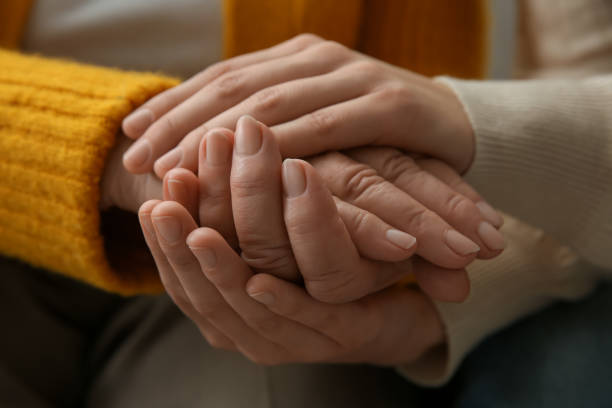 istock Young and elderly women holding hands together, closeup 1425550219