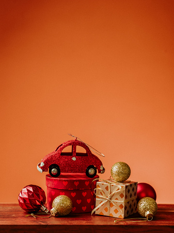 Christmas still life with red car ornate christmas tree decoration 
Red and warm orange background, still life with copy space