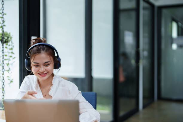 istock woman using a computer and earphone during a video conference 1425553088