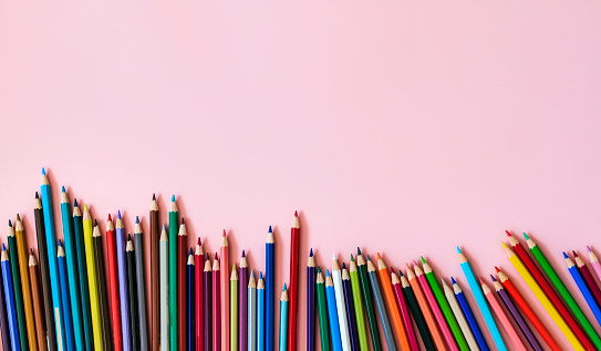 Back to school concept with colored pencils  arranged in a row. Close up. Art and craft. Design professional.  Education. Office supplies. Flat lay. Copy space. Top view. Pastel colors. LGBTQIA Rights.