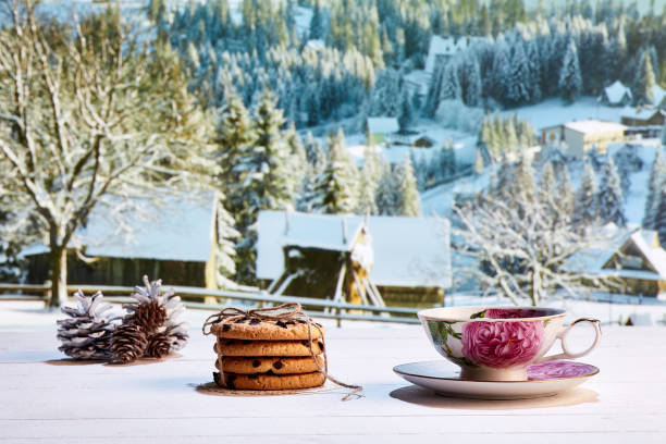 istock Cup of warm tea with delicious biscuits on winter countryside background 1425553704