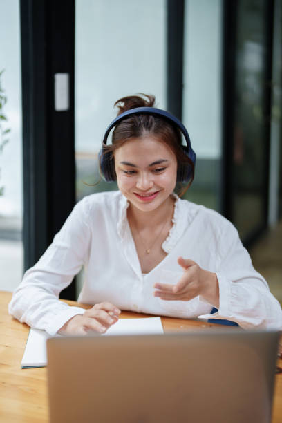 istock woman using a computer and earphone during a video conference 1425553846