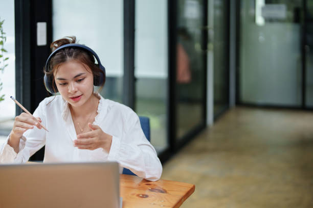istock woman using a computer and earphone during a video conference 1425553957
