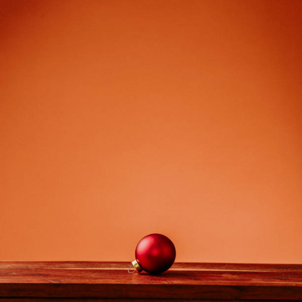 Christmas still life with red christmas tree decoration ornament bauble\nRed and warm orange background, still life with copy space