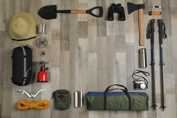 istock Frame of different camping equipment on wooden background, flat lay. Space for text 1425554341