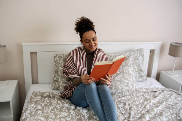 istock Young woman reading a book 1425555739