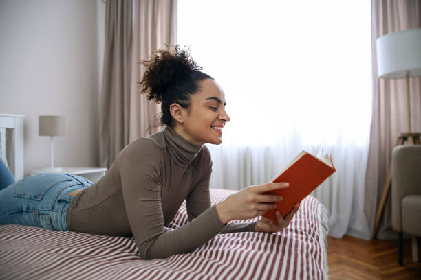 istock Woman reading a book at home 1425555781
