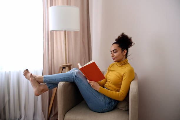 istock Young woman reading a book 1425555983