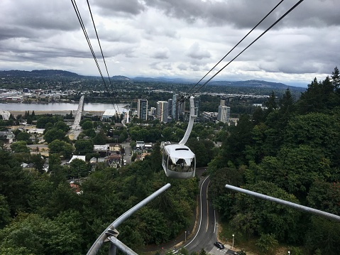 View of Portland’s Aerial Tram, the City, Willamette River and the Cascade Mountains on a cloudy day.