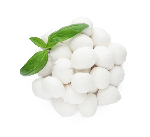 istock Pile of mozzarella cheese balls and basil on white background, top view 1425556400
